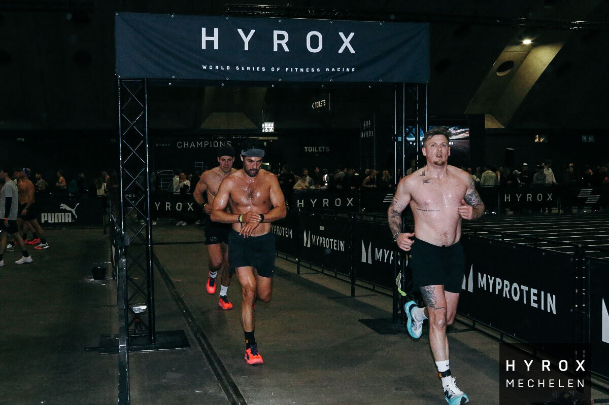Members running under the HYROX arch at Mechelen