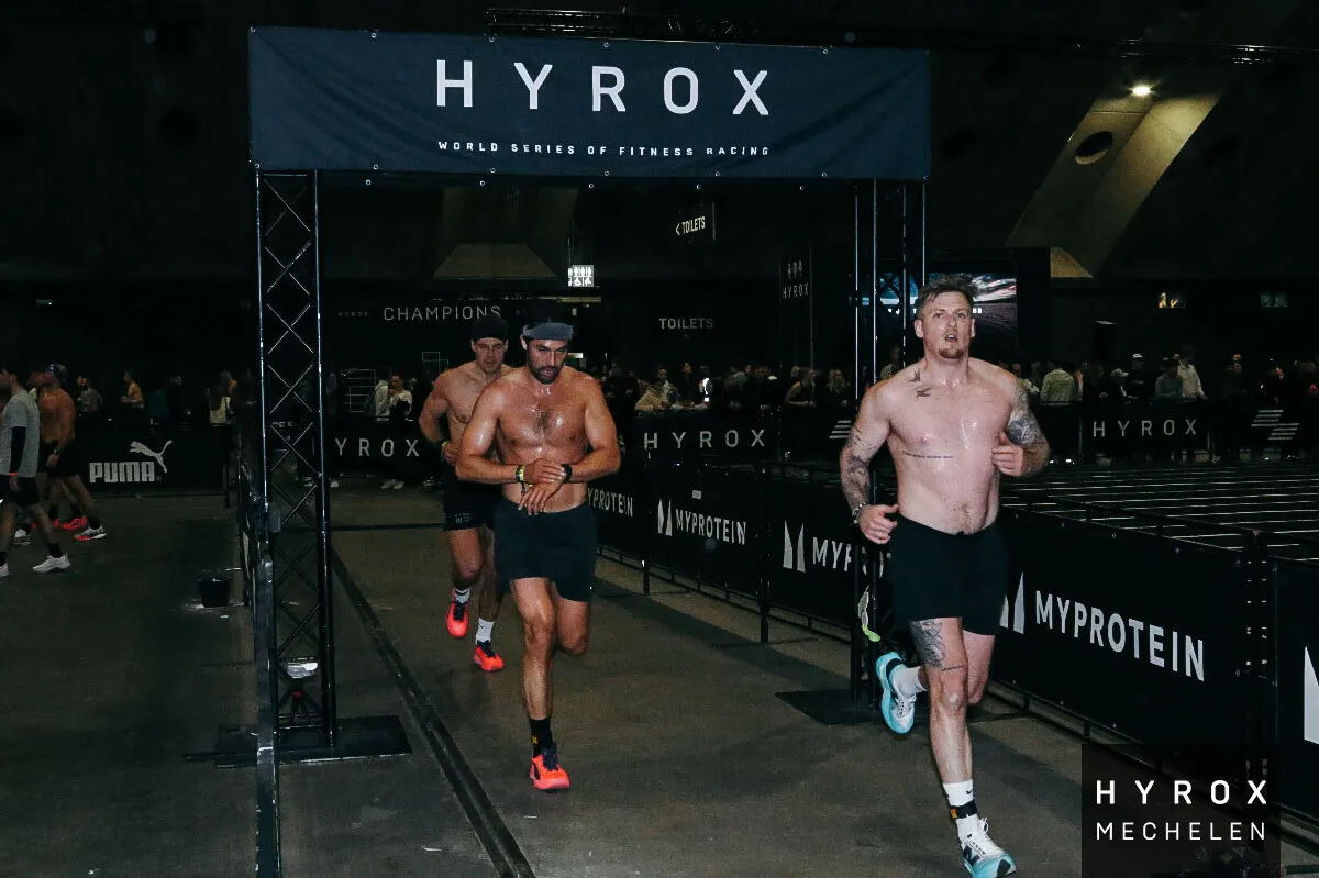 Members running under the HYROX arch at Mechelen